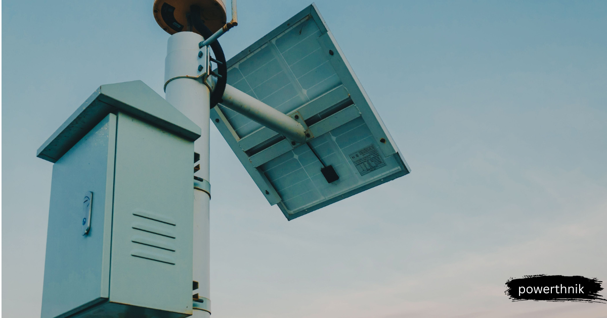 Solar battery control box and solar panel mounted on a metal pole against a clear blue sky background