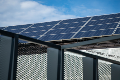 Photovoltaic panel dimensions shown on rooftop solar array with rows of monocrystalline panels