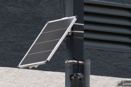 Solar Panel Inverter mounted with a solar panel on an exterior building wall, providing efficient DC to AC power conversion for a residential solar energy system.
