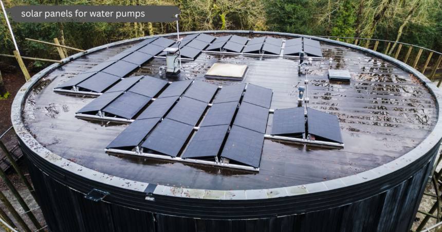 Aerial view of black solar panels for water pumps mounted on a large circular rooftop structure surrounded by green trees.
