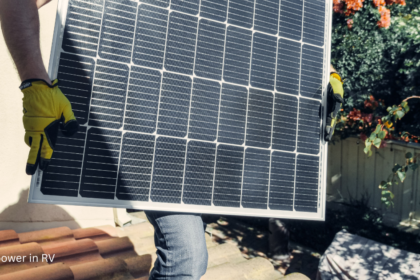 Person installing solar power in RV setup by carrying a solar panel onto a rooftop