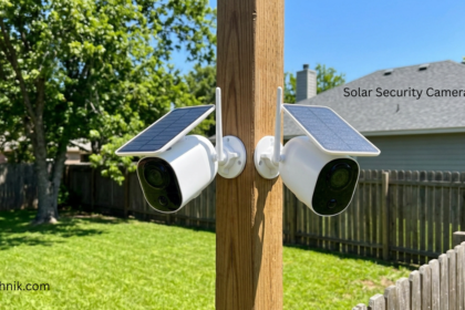 Two solar security cameras with solar panels mounted on a wooden fence post monitoring a backyard