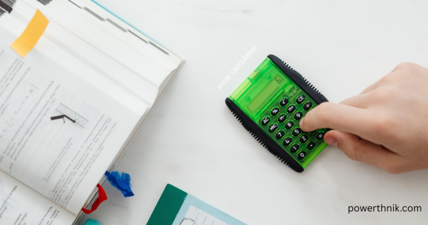 Person using a green solar calculator on a desk with an open textbook to estimate solar panel output