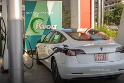 White Tesla Model 3 charging at Rolec EV charger station with KVOLT branding signage
