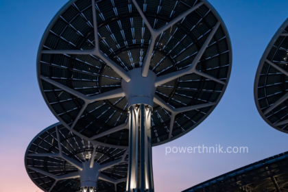 Futuristic tree-like solar devices capturing renewable energy under a twilight sky.