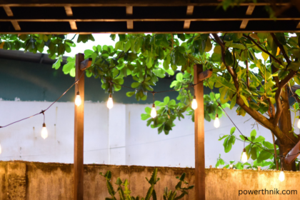 Waterproof Outdoor Fence Lights illuminating a wooden garden fence with warm evening light and greenery.