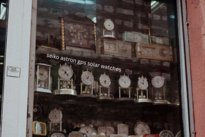 Seiko Astron GPS solar watches displayed near vintage clocks in a traditional watch shop window
