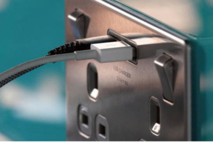 Home battery storage UK without solar: USB cable plugged into a brushed steel wall socket with USB charger port