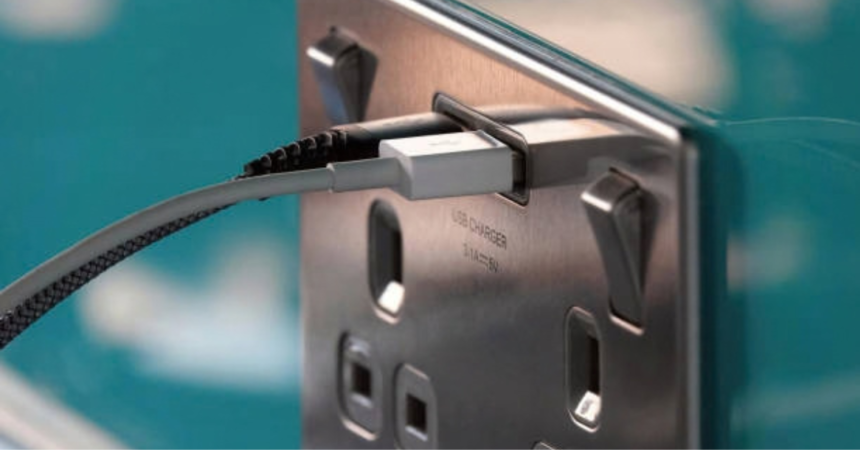 Home battery storage UK without solar: USB cable plugged into a brushed steel wall socket with USB charger port