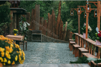 Rustic garden pathway with wooden fence, string bulbs on wooden posts and flower pots, perfect spot to add solar lanterns for fence decor.