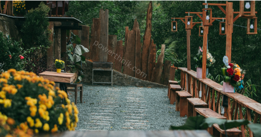 Rustic garden pathway with wooden fence, string bulbs on wooden posts and flower pots, perfect spot to add solar lanterns for fence decor.