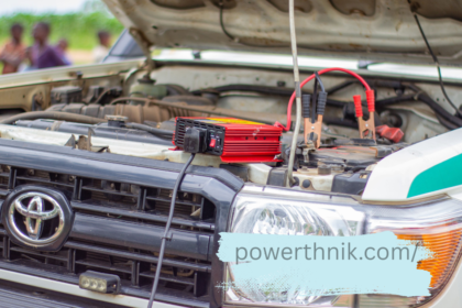 Red smart charger clamped to a Toyota battery, similar to charging a caravan leisure battery.