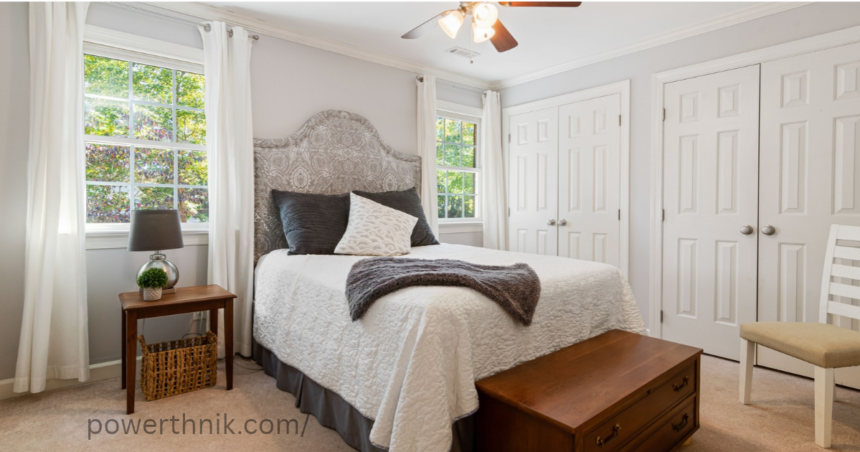 Ceiling fan light in a modern bedroom with white bedding and natural light.